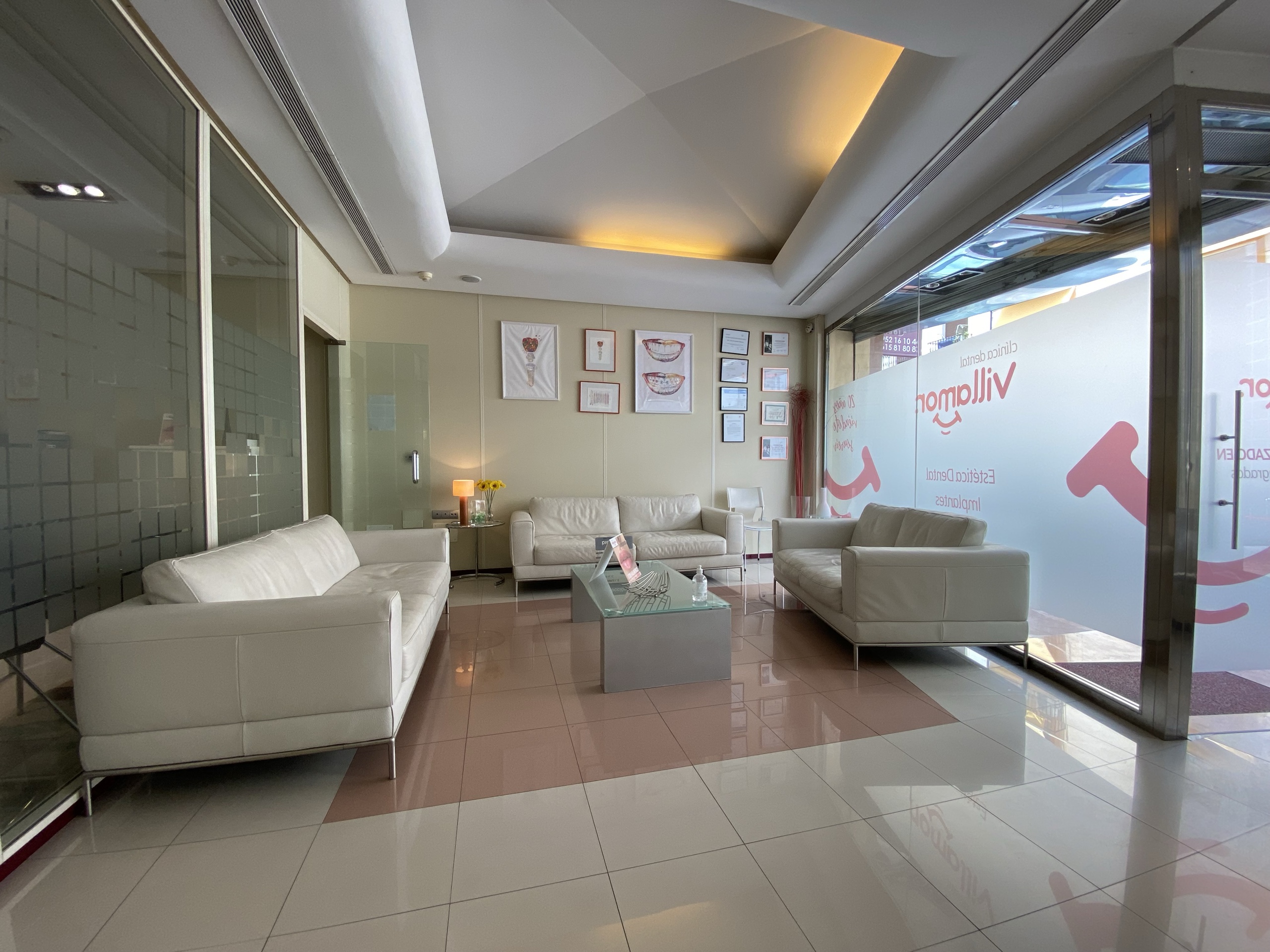 Sala de espera de Clínica Dental Villamor, con el rótulo de la clínica en el escaparate